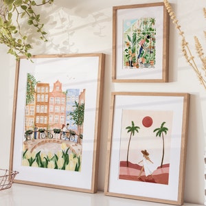 May include: Three framed art prints in light wood frames. The largest print depicts a canal scene with Dutch houses, bicycles, and yellow tulips. The top right print shows a person gardening in a greenhouse. The bottom right print features a person walking between palm trees under a red sun.