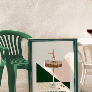 May include: A framed print with a green, pink, and yellow geometric design. A martini glass with coffee beans and a woman diving into the glass is depicted. The text "Espresso Martini" is at the bottom of the print.