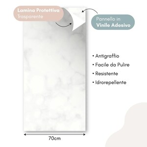 May include: A rectangular, white marble-patterned vinyl adhesive panel, 70cm wide, with a protective transparent layer. Features include scratch resistance, easy cleaning, durability, and water resistance. Text in Italian.