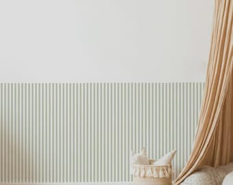 May include: A room with a light green and white striped wall, a woven basket with white fabric, and a tan curtain. The floor is made of wooden planks.