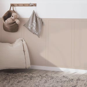 Puede incluir: Una habitación infantil de tonos neutros. Se ve una cesta de mimbre con un osito de peluche, una bolsa de tela con letras del alfabeto y una almohada decorativa. La pared está pintada de color beige claro.