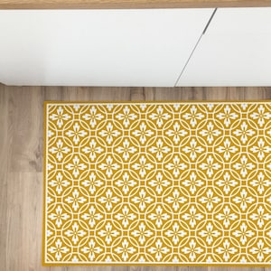 May include: A yellow and white patterned kitchen rug with a geometric design. The rug has a white border and a repeating pattern of white flowers and circles on a yellow background.