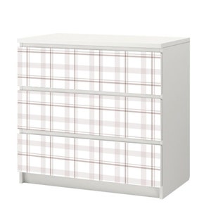 May include: White dresser with three drawers featuring a pink and white plaid pattern.