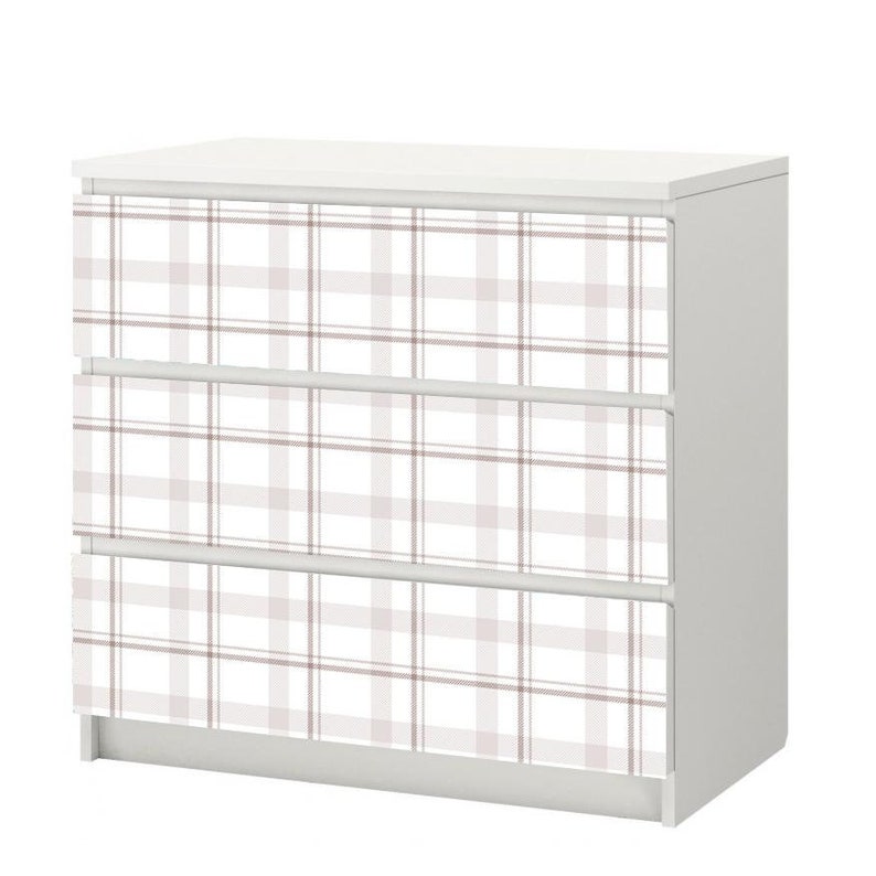May include: White dresser with three drawers featuring a pink and white plaid pattern.