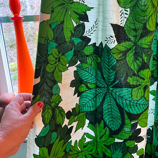 Scandinavian retro curtains in green fabric with leaves patterns.