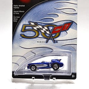 May include: A blue and silver die-cast toy car, a Chevrolet Corvette SR-2, in a plastic blister pack. The car is part of the Hot Wheels 50th Anniversary Series and is numbered 1/4. The packaging features the Hot Wheels logo and the words "Highly Detailed Engines", "Special Wheels & Tires", and "Die-Cast Metal Body".