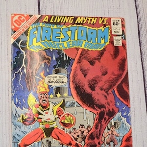 May include: Vintage comic book cover titled "A Living Myth vs. Firestorm the Nuclear Man." The cover features a red, muscular figure and a superhero in a red and yellow suit. Text includes "Either this is a very bad dream" and "No. 6 Nov."