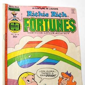 May include: A vintage Richie Rich Fortunes comic book, issue number 36, dated September. The cover features a colorful rainbow graphic, a mansion, and illustrations of Richie Rich and Gloria with a speech bubble saying, Look, Gloria... there's a rain dough!