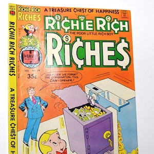 May include: A vintage Richie Rich Riches comic book, issue number 39, featuring an orange cover with a purple safe filled with money. The text reads A Treasure Chest of Happiness, Richie Rich The Poor Little Rich Boy, and Riches, priced at 35c.