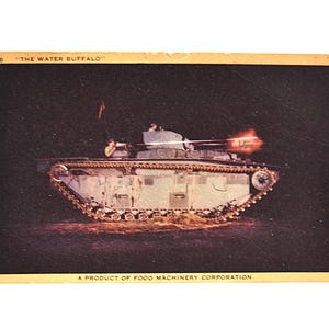 May include: Vintage postcard featuring a military tank, the "Water Buffalo," firing its weapon. The tank is light-colored with visible tracks and a turret. The image has a dark background and the text "A PRODUCT OF FOOD MACHINERY CORPORATION."