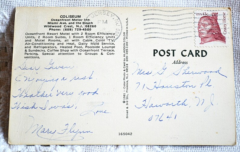 May include: A vintage postcard with handwritten messages and an address. The postcard features a stamp with a portrait of Crazy Horse. The text on the card mentions a motel in Wildwood Crest, NJ.