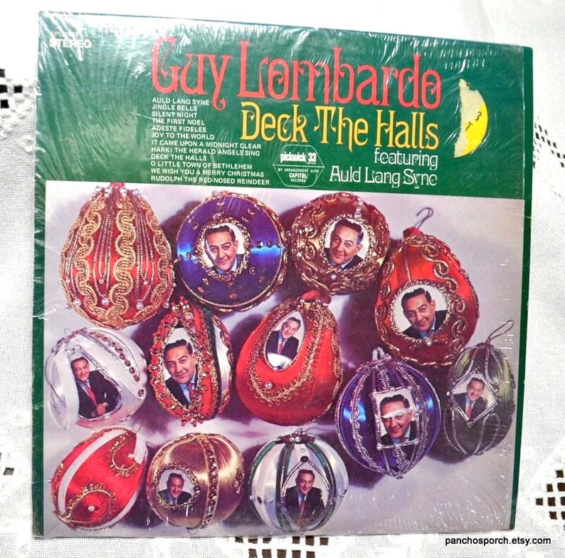 May include: A vintage vinyl record album titled "Guy Lombardo Deck The Halls" featuring Auld Lang Syne. The album cover is green and features a collection of decorative Christmas ornaments with portraits inside. The album is sealed in plastic.