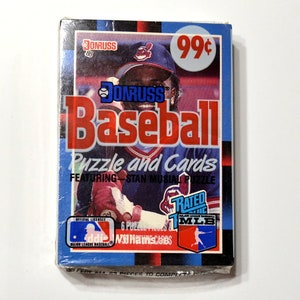 May include: A vintage Donruss Baseball puzzle and cards set featuring Stan Musial. The packaging is blue, red, and white, with a 99¢ price sticker. The set includes 6 puzzle pieces and is an official MLB licensed product.