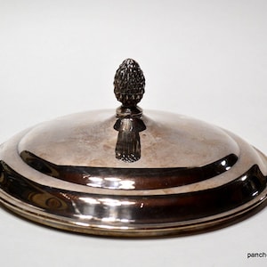 May include: Silver plated serving dish lid with a decorative pine cone finial.