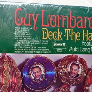 May include: A vintage vinyl record album cover for "Deck The Halls" by Guy Lombardo, featuring Christmas songs. The cover is green with red and yellow text. Ornaments with a portrait are at the bottom.