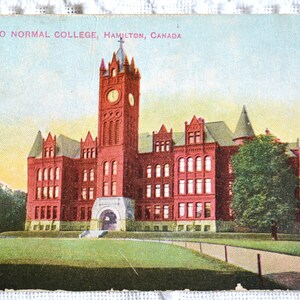 May include: A vintage postcard depicting Ontario Normal College in Hamilton, Canada. The red brick building features a tall clock tower with a cross on top. The postcard is in good condition with some minor wear and tear.