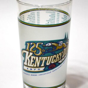 Pu&ograve; includere: Un bicchiere trasparente con un design colorato che commemora il 125&deg; Kentucky Derby nel 1875. Il design include un cavallo e un fantino, le parole "Kentucky Derby" e la localit&agrave; "Churchill Downs, Louisville, Kentucky".