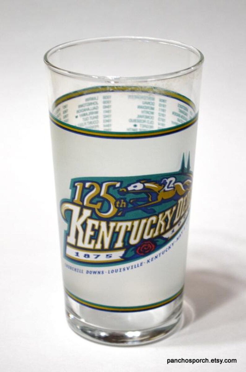 Pu&ograve; includere: Un bicchiere trasparente con un design colorato che commemora il 125&deg; Kentucky Derby nel 1875. Il design include un cavallo e un fantino, le parole "Kentucky Derby" e la localit&agrave; "Churchill Downs, Louisville, Kentucky".