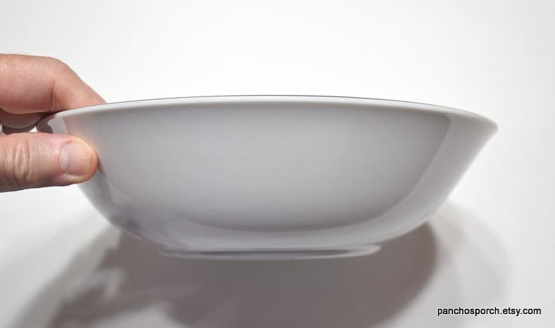 May include: A white ceramic bowl with a slightly rounded rim. The bowl is empty and appears to be new.