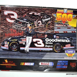 May include: A 1996 Food City 500 souvenir magazine featuring a graphic illustration of a black number 3 Goodwrench race car, a driver leaning against the vehicle, and the text The Intimidator, Food City 500, March 31, 1996, and NASCAR logos.