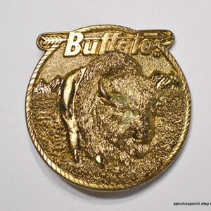 May include: Gold-toned metal belt buckle featuring a detailed image of a buffalo with the word "Buffalo" above it.