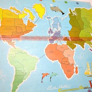 May include: Vintage Risk! board game with a world map design. The game board features continents in various colors, with illustrations of a whale, dolphins, and a sailboat. The game's title is displayed in red.