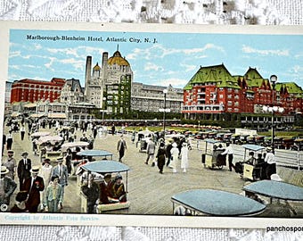 May include: Vintage postcard featuring a black and white photo of the Marlborough-Blenheim Hotel in Atlantic City, New Jersey. The hotel is a large, grand building with many windows and a large, ornate entrance. The postcard is dated 1910.