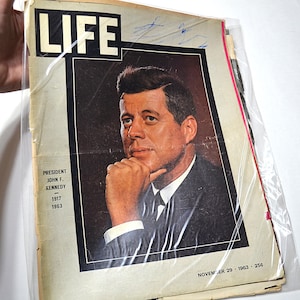 May include: A vintage LIFE magazine issue dated November 29, 1963, featuring a portrait of President John F. Kennedy on the cover. The text reads President John F. Kennedy 1917-1963. The magazine is encased in a clear protective plastic sleeve.