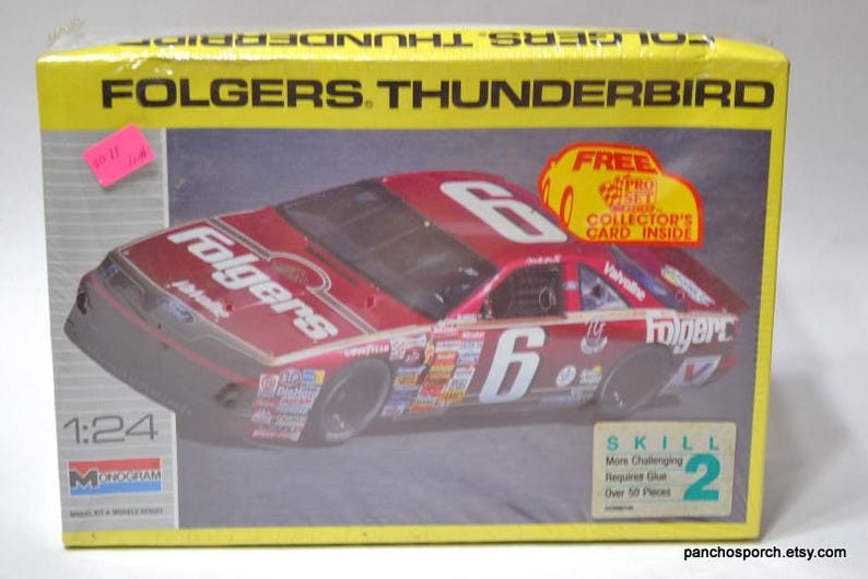 Puede incluir: Un kit de modelo de coche Folgers Thunderbird en una caja amarilla y gris. El coche de carreras rojo tiene el n&uacute;mero 6 y la marca Folgers. La caja incluye una pegatina "Tarjeta de coleccionista GRATIS en el interior" y el logotipo de Monogram.
