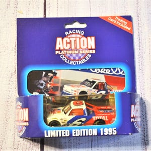 May include: A Racing Action Platinum Series limited edition 1995 die-cast race truck in white, red, and blue with the number 6 on the side. The truck is packaged in a blue cardboard display box with a clear window and includes a trading card.