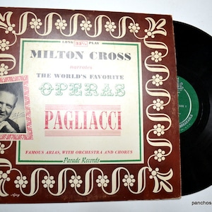 May include: A vintage vinyl record album titled Milton Cross Narrates The World's Favorite Operas Pagliacci by Parade Records. The square cardboard sleeve features a brown border with white floral patterns, a black and white portrait, and text.