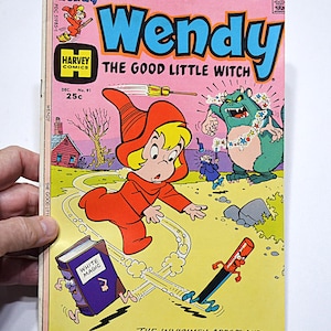May include: A vintage comic book titled "Wendy The Good Little Witch" featuring a cartoon witch in a red outfit. The cover art includes a green monster, a purple book labeled "White Magic," and the text "The Invisimen Arrive and The Enchanted Forest Goes Wild!!"