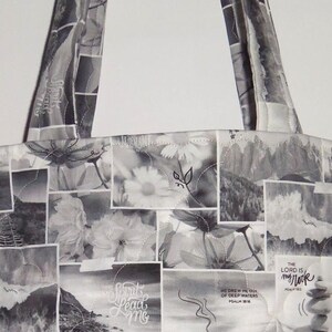 May include: A tote bag with a patchwork design in black and white. The bag features a variety of images, including flowers, landscapes, and text. The handles are made of the same fabric. The text includes the words "Sight", "Spirit Lead Me", and "The Lord is my Rock".