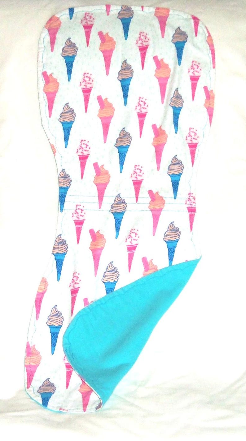 Op de afbeelding: Een baby-uitscheurdoek met een patroon van ijsjes in roze, oranje, blauw en bruin op een witte achtergrond. De achterkant is effen turquoise.