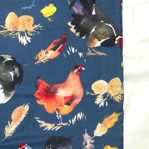 May include: A dark blue fabric featuring watercolor illustrations of chickens, roosters, chicks, feathers, and nests. The chickens are in shades of red, orange, black, and white. The chicks are yellow.