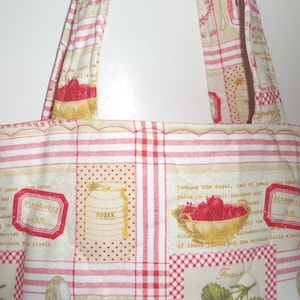 May include: A quilted fabric tote bag featuring a cream and red pattern with illustrations of strawberries, sugar canisters, and jam labels. The design includes text snippets about cooking jam and red striped sections with two matching fabric handles.