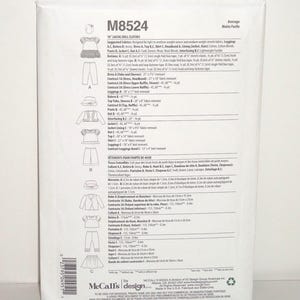 May include: A white package featuring a doll clothes sewing pattern, model M8524, with illustrations of doll clothing designs. The package includes text in English and French, with measurements in inches and centimeters.