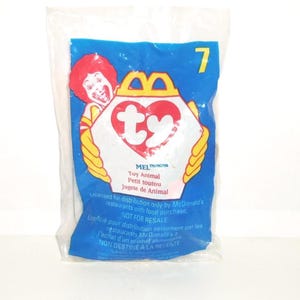 May include: A sealed clear plastic McDonald's Happy Meal toy bag featuring a blue background, the number 7, a graphic of Ronald McDonald, and a white heart-shaped Ty logo. The text reads Mel, Toy Animal, and includes licensing information.