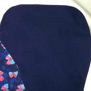 May include: A dark blue fabric with a smooth texture. The fabric is folded in half and the edges are visible.