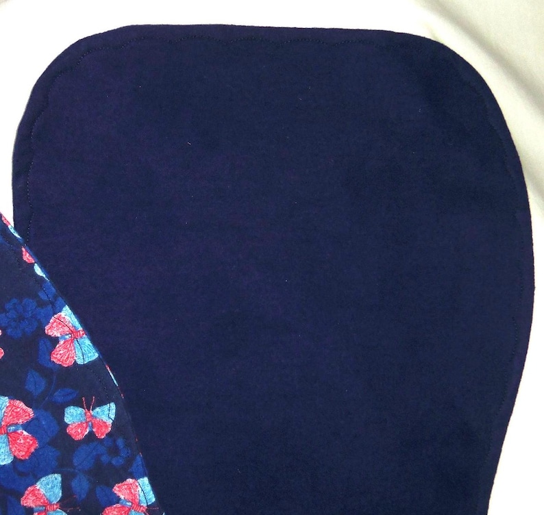 May include: A dark blue fabric with a smooth texture. The fabric is folded in half and the edges are visible.