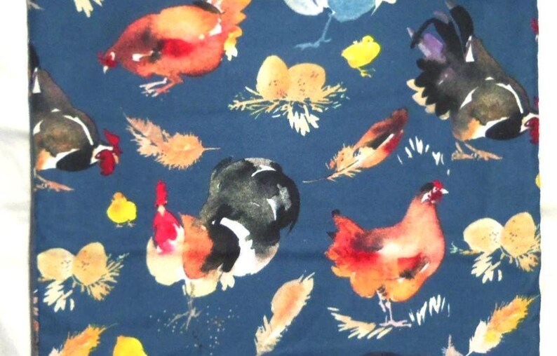 May include: A navy blue fabric featuring a watercolor design of chickens, roosters, feathers, and nests with eggs. The chickens are in shades of red, orange, black, and white. Yellow chicks and feathers are scattered across the fabric.