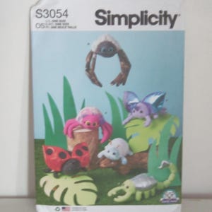 May include: Simplicity sewing pattern S3054 featuring instructions for plush insect toys. The cover displays a ladybug, a spider, a butterfly, a scorpion, and a beetle in a garden setting. The text S3054 and Simplicity are printed at the top.
