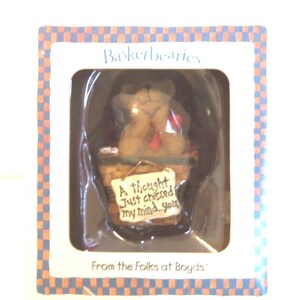 May include: A boxed "Basketbearies" figurine featuring a brown bear in a woven basket. The bear holds a sign that reads "A thought just crossed my mind...you." The box has a blue and orange checkered border and text that says "From the Folks at Boyds."