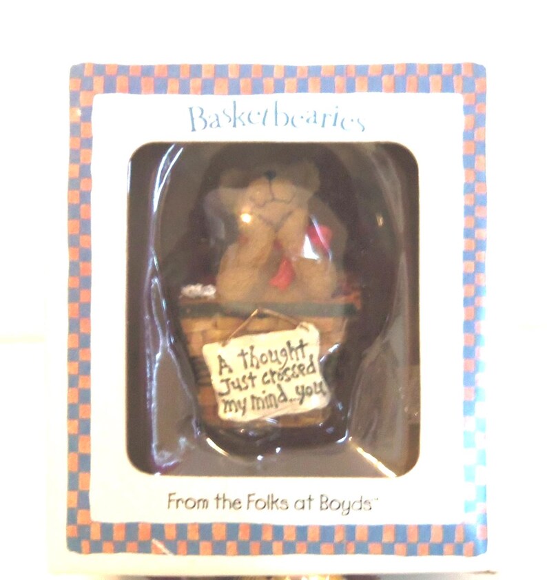 May include: A boxed "Basketbearies" figurine featuring a brown bear in a woven basket. The bear holds a sign that reads "A thought just crossed my mind...you." The box has a blue and orange checkered border and text that says "From the Folks at Boyds."