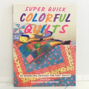 May include: A softcover book titled Super Quick Colorful Quilts edited by Rosemary Wilkinson. The cover features a stack of vibrant, multi-colored patchwork quilts with floral and geometric patterns. The text 20 Sparkling Designs for Fast Quilts is printed at the bottom.
