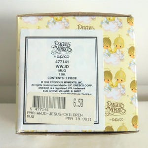 May include: A square cardboard box for a Precious Moments mug featuring a repeating pattern of children with halos on clouds. The label displays the text Precious Moments by Enesco, 477141, WWJD MUG, 1 Stl., and includes a barcode with the number 477141.