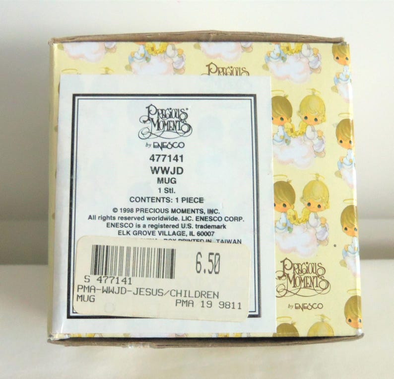 May include: A square cardboard box for a Precious Moments mug featuring a repeating pattern of children with halos on clouds. The label displays the text Precious Moments by Enesco, 477141, WWJD MUG, 1 Stl., and includes a barcode with the number 477141.