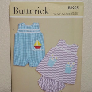 May include: Butterick sewing pattern B6905 for children's clothing in sizes NBN-XLG. The envelope displays a blue gingham romper with a sailboat applique and a purple striped top with matching bloomers featuring flower pot appliques.