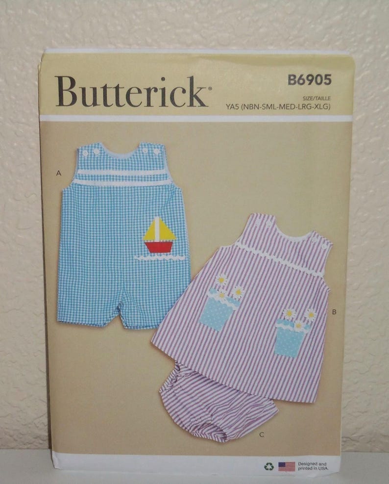 May include: Butterick sewing pattern B6905 for children's clothing in sizes NBN-XLG. The envelope displays a blue gingham romper with a sailboat applique and a purple striped top with matching bloomers featuring flower pot appliques.