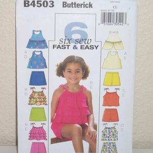 May include: Butterick sewing pattern B4503 for children's clothing, featuring illustrations of various tops and shorts in floral, striped, and solid fabrics. The white envelope displays the text 6 six sew FAST & EASY and a size range of 6-7-8.